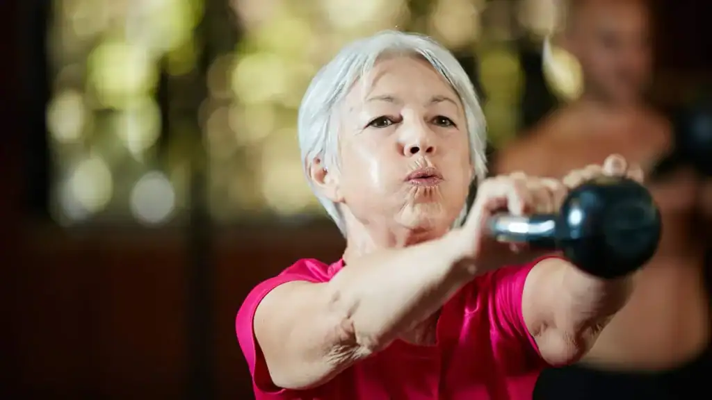 Older woman doing weight training East Malling to help her strength and longevity 