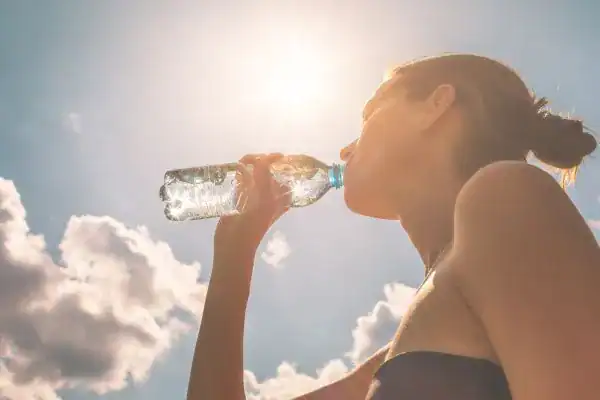 Hydration: The Secret Ingredient for a Toned Stomach and Enhanced Fitness 3 Image of woman drinking water to hydrate East Malling after run.